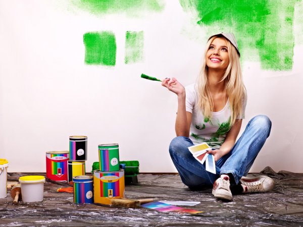 chica pintando su casa
